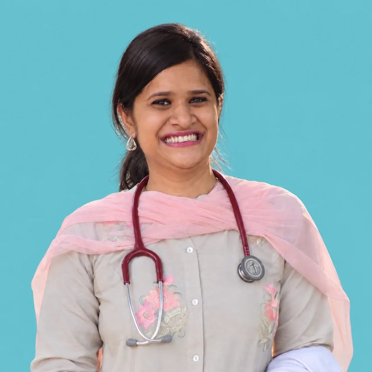 Dr. Shreshtha Gupta, smiling, with a stethoscope around her neck.